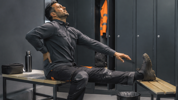 Warehouse worker stretching legs and lower back after a shift