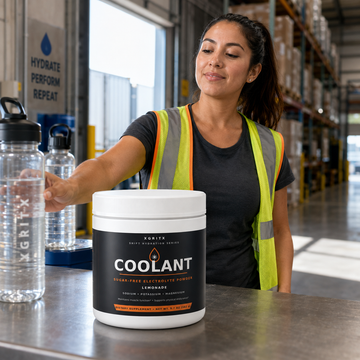 Woman warehouse worker using XGRITX COOLANT sugar-free electrolyte powder at a hydration station
