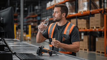 Warehouse worker using water and a balanced snack to stay focused