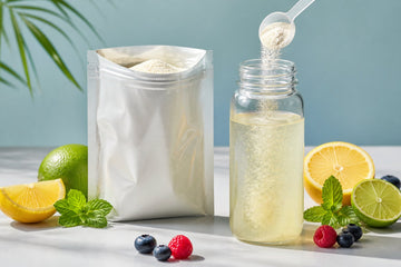 Citrus-colored electrolyte drink with dissolving powder, fruit slices, berries and mint