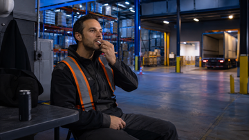 Night shift warehouse worker using a caffeine energy strip during a designated break