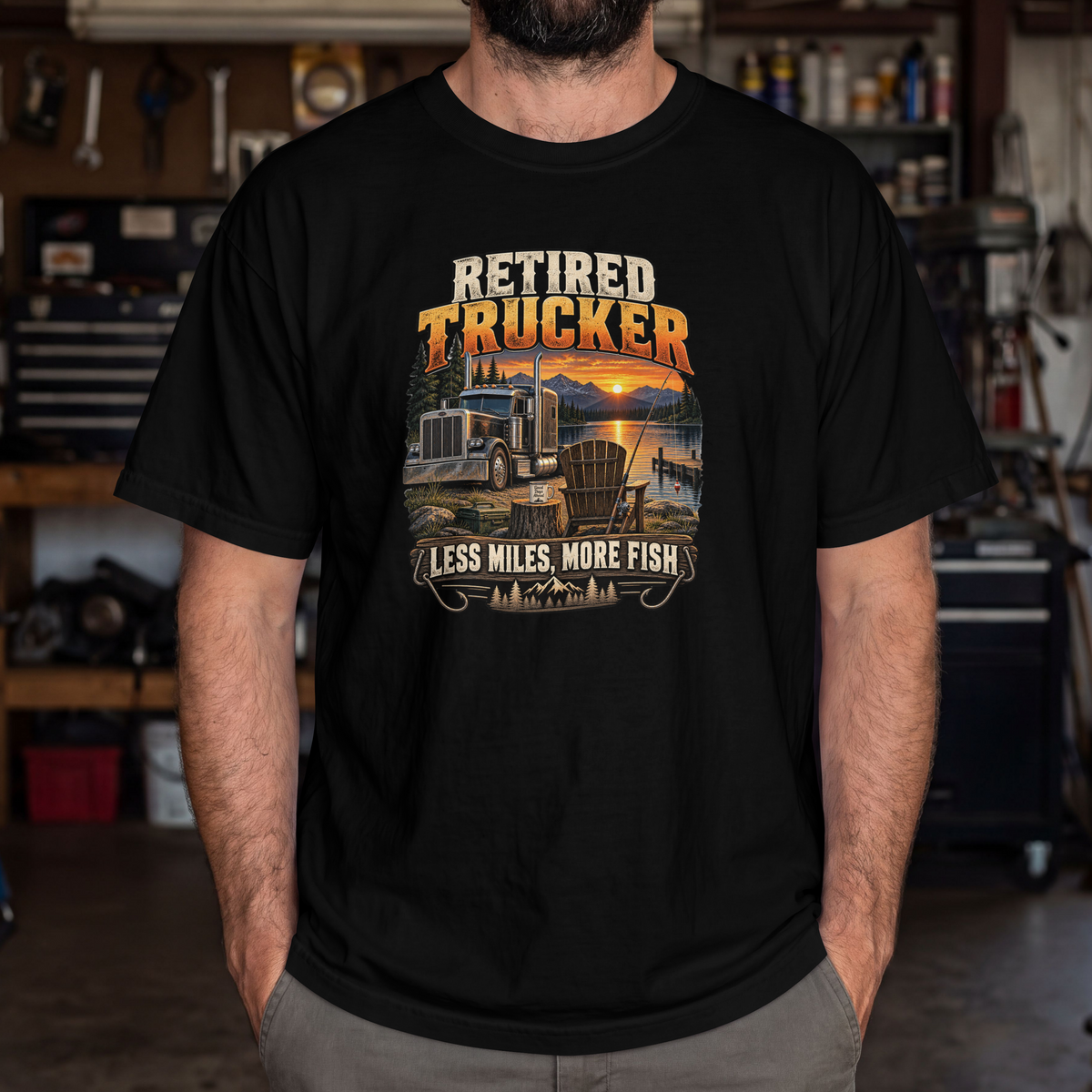 Black Retired Trucker Less Miles More Fish T-shirt worn by a model in a workshop, showing the front truck and fishing graphic.