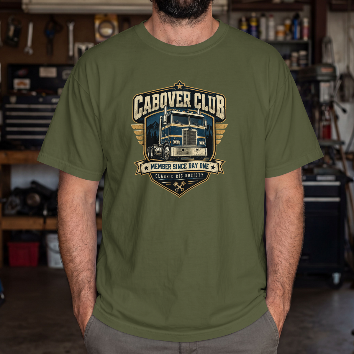 Hemp Cabover Club T-shirt with blue and gold vintage cabover truck graphic and Member Since Day One lettering, male model in workshop.