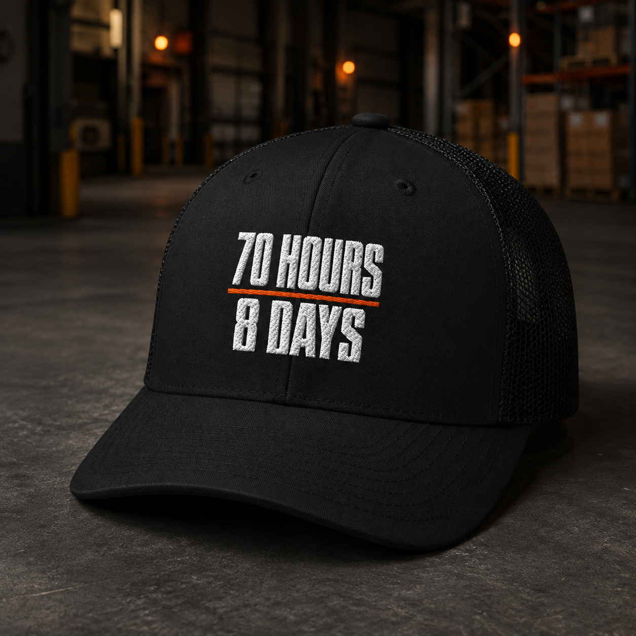 70 Hours in 8 Days black embroidered trucker hat in a warehouse setting