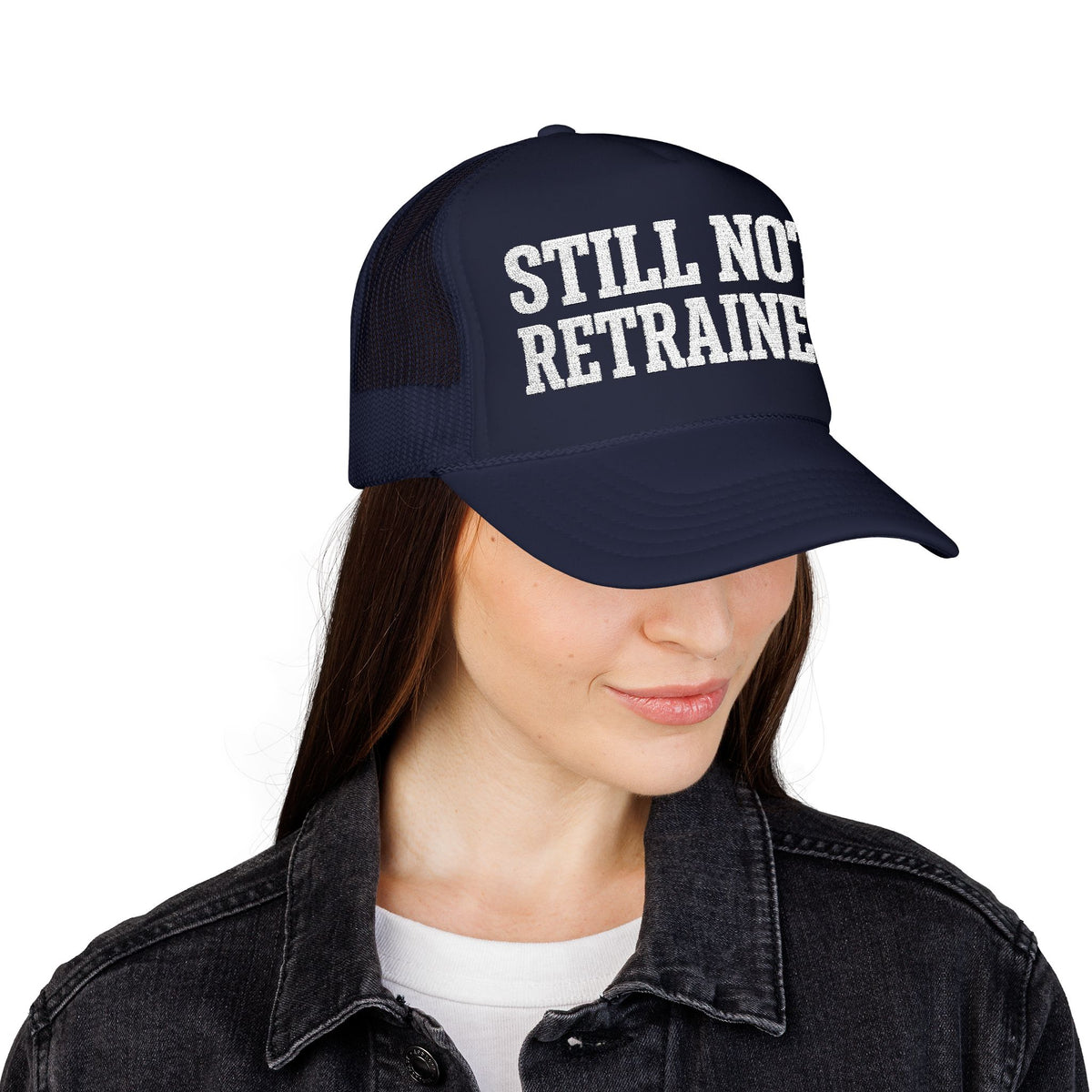 Woman wearing the dark navy Still Not Retrained foam trucker hat with a denim jacket.