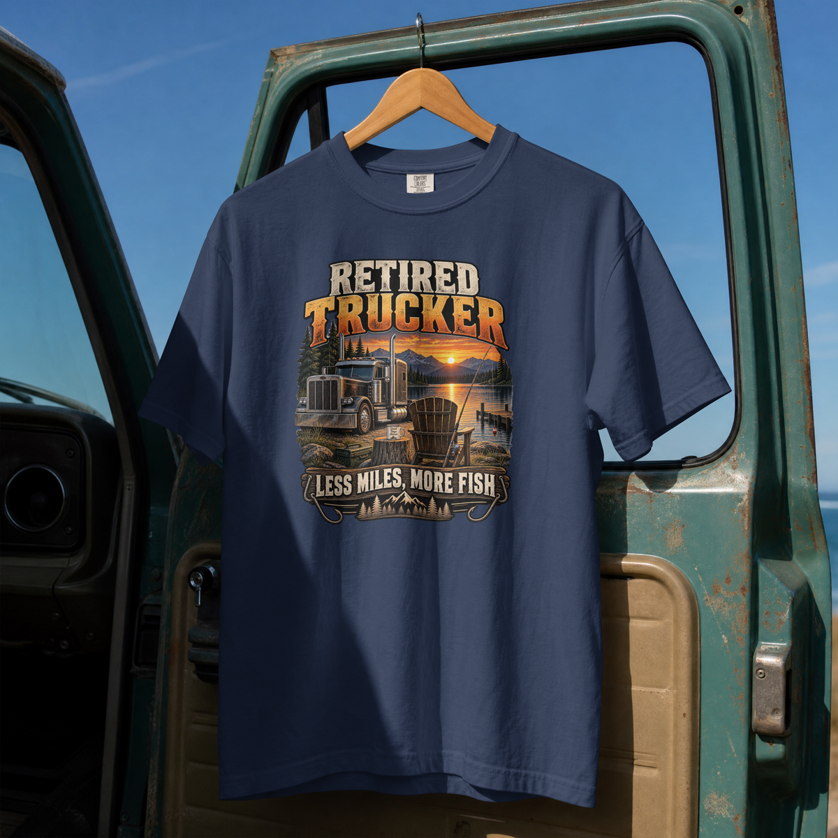 True Navy Retired Trucker Less Miles More Fish T-shirt, full front hanging view with truck and lakeside fishing graphic.