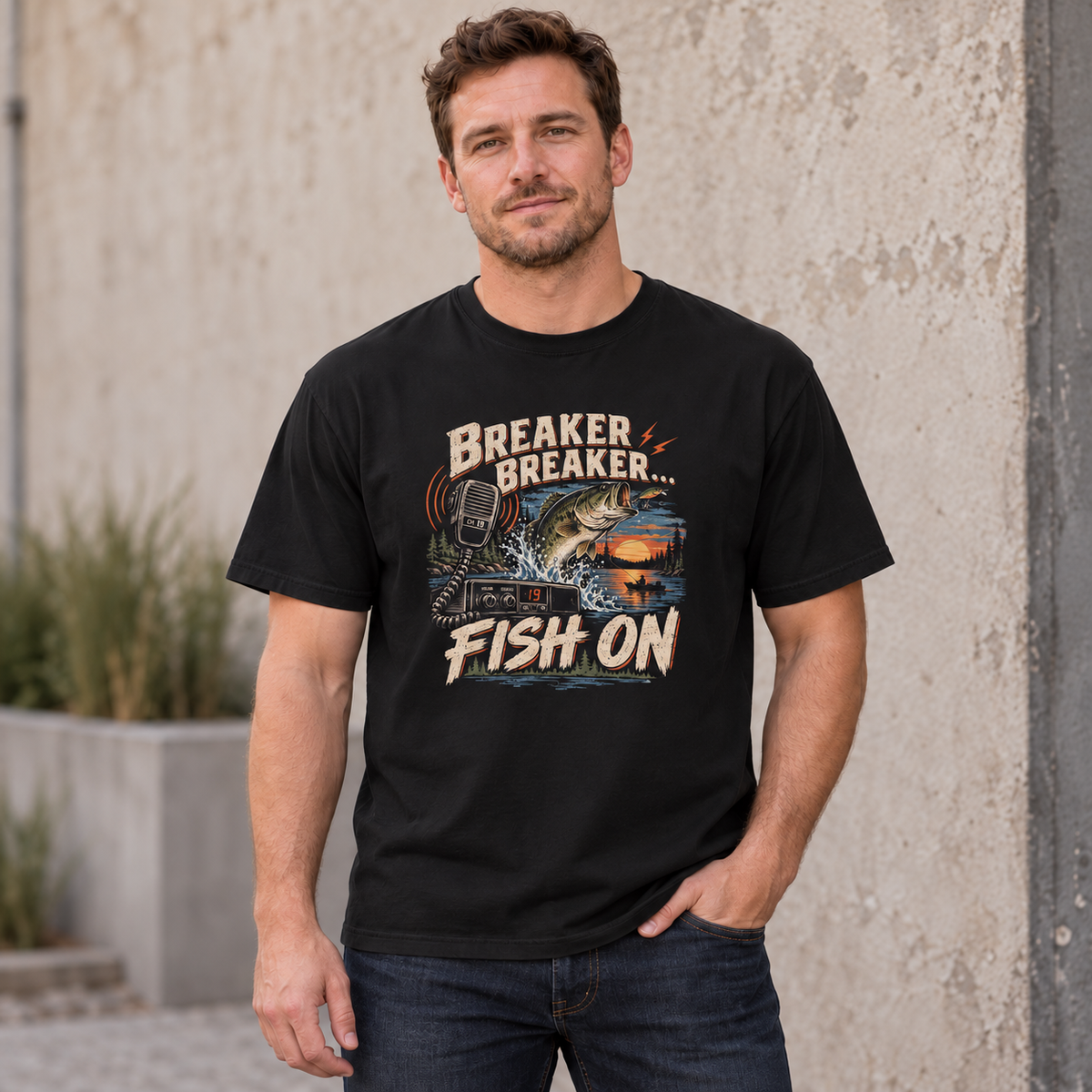 AI lifestyle mockup of a Black Breaker Breaker Fish On T-shirt worn by a male model, with a centered bass, CB radio and sunset front graphic.