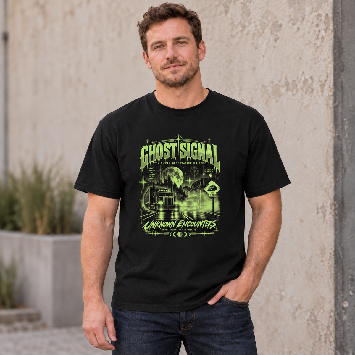 AI lifestyle mockup of a Black Ghost Signal Unknown Encounters T-shirt worn by a male model, showing the green two-truck front graphic.